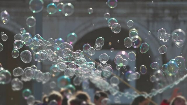 Street performer creating large soap bubbles for a crowd