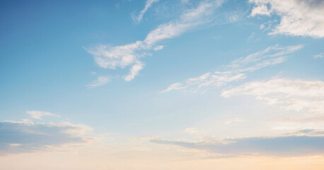 Breathtaking view of a pale blue sky with wispy white clouds at sunset. Background photos for banners, posters and wallpapers.