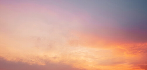 Serene and peaceful sunset sky with soft, hazy clouds and warm orange tones. Background photos for banners, posters and wallpapers.