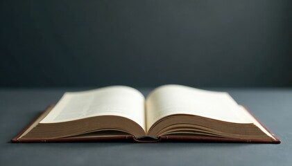 A blank book lying on a dark grey surface with a faint outline of a tree in the background, Simple design , Grey book