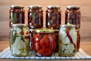 Pickling vegetables in glass jars. Patisson, tomato, paprika, hot pepper, garlic, black pepper, bay leaf, vinegar.