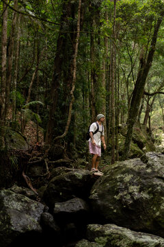 Man hiking over rocks along a waterfall trail in Australia