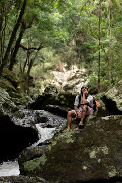 Man sitting over rocks along a waterfall trail in Australia