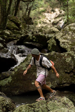 Man hiking over rocks along a waterfall trail in Australia