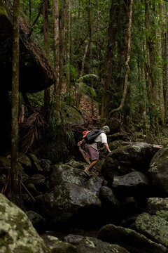 Man hiking over rocks along a waterfall trail in Australia