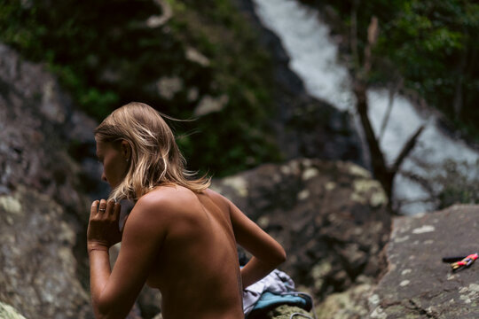 A woman goes swimming in a waterfall