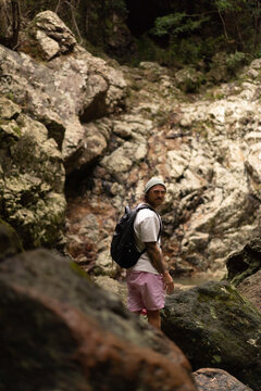 Man over rocks along a waterfall trail in Australia