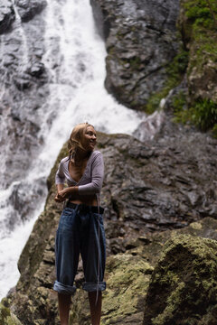A woman goes swimming in a waterfall
