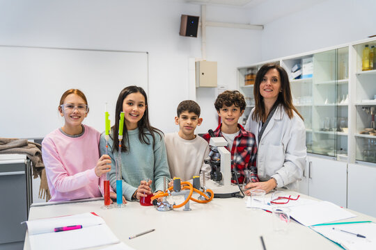 Elementary school students and their teacher performing a chemistry experiment in the school laboratory