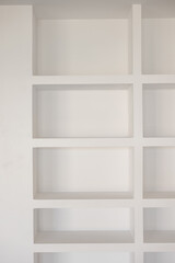 Built-in white minimalist shelving unit with geometric design