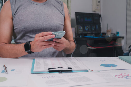 Data Driven Insights Person In Black Smartwatch Studies Data On Smartphone At Home Workspace, Analyzing Charts With Clipboard Monitor Interface