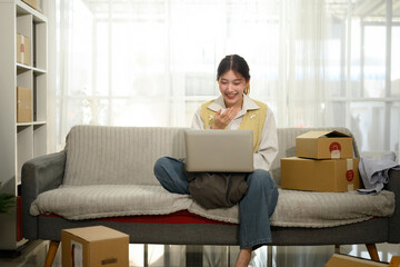 Young Businesswoman Using Laptop on Video Call Managing E-commerce Orders