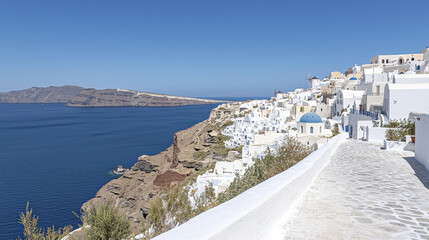 Obraz premium stunning view of whitewashed buildings along coastline, overlooking deep blue sea and rocky cliffs, evokes sense of tranquility and beauty