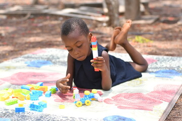 beautiful african Child playing with colorful toy blocks