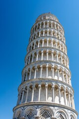 Famous tower in Pisa in Italy, Tuscany against blue sky.