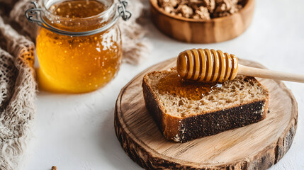 A rustic wooden table featuring a loaf of multigrain bread and a jar of honey