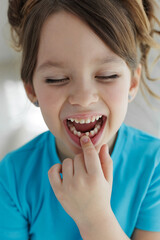 Loss baby teeth. Baby teeth have to fall out to make way for permanent teeth to grow. Girl showing her mouth without one tooth. Most kids are excited to feel a tooth wiggle. Tooth fairy concept.