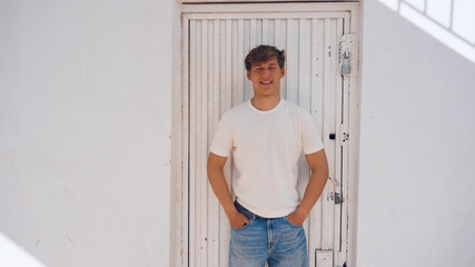 Young handsome man portrait, white metal door on background