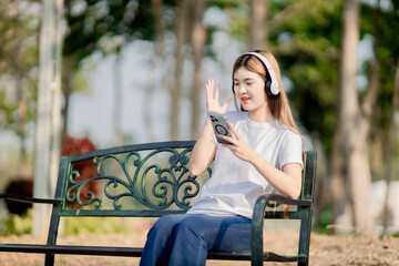 Asian women sit and listen to music in the park.