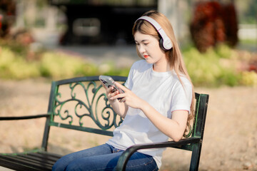 Asian women sit and listen to music in the park.