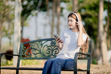 Asian women sit and listen to music in the park.