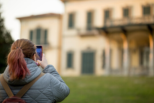 Donna con telefono che fotografa edificio
