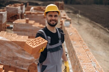 Showing the brick. Construction worker is at job with outdoors