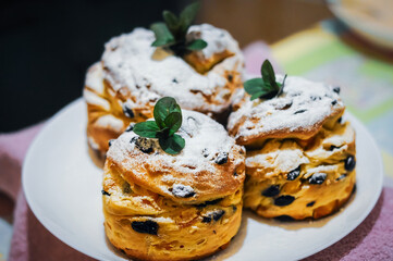 Delicious homemade muffins, dusted with powdered sugar and garnished with mint, sit ready to eat.