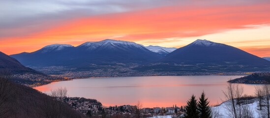 Scenic vista capturing dawn's glow over snowy mountain range and placid lake
