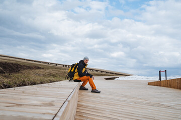 An Adventurous Traveler is found Relaxing on a Beautiful Scenic Boardwalk while enjoying...