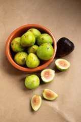 Close-Up of Fresh Green Figs in a Bowl on Brown Background