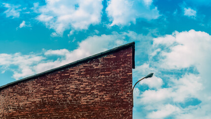 fragment of a brick building with a lantern against a blue sky w
