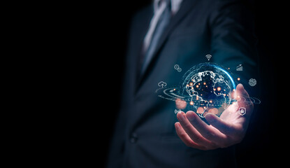 A businessman in a suit presents a glowing digital Earth hologram, symbolizing global connectivity, technology, and innovation in business.

