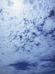 Blue Sky With Soft Fluffy Cloud Pattern and Bright Sunlight