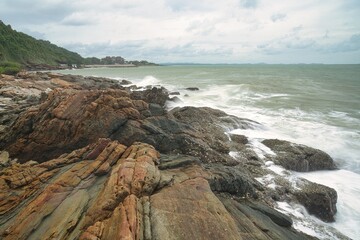 The seaside on a cloudy, windy day with large rocks in the foreground