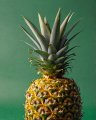 Pineapple photographed against a solid green background.