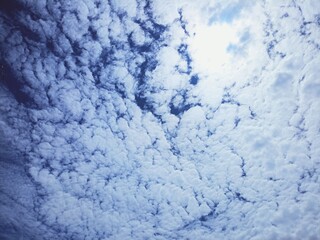 Clear Sky with Fluffy White Clouds and Sunlight Peeking Through