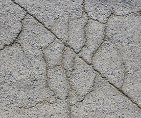 Concrete surface with intricate cracking patterns captured during midday in an urban area