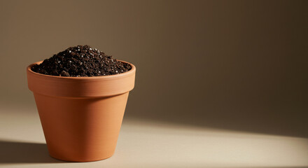 Fertile soil substrate in a clay pot on a neutral background  