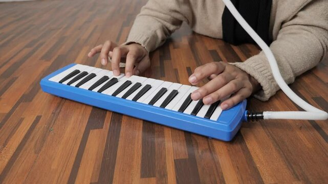 Anonymous woman playing pianica, melodica blow organ