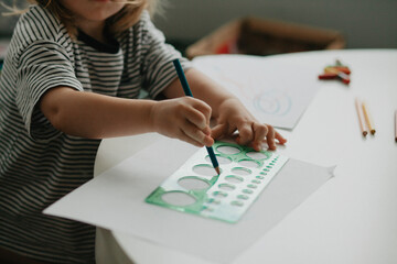 Little girl draws with pencil
