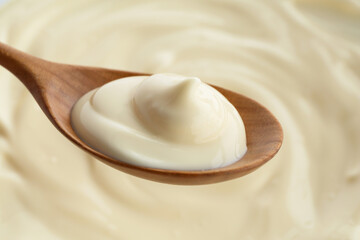 Spoon with delicious mayonnaise sauce, closeup view