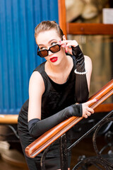 Young female model in black dress in Breakfast at Tiffany's style