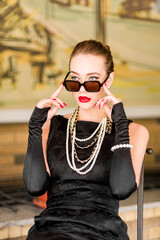 Young female model in black dress in Breakfast at Tiffany's style