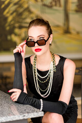 Young female model in black dress in Breakfast at Tiffany's style