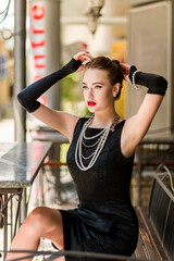 Young female model in black dress in Breakfast at Tiffany's style