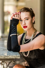 Young female model in black dress in Breakfast at Tiffany's style