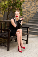 Young female model in black dress in Breakfast at Tiffany's style