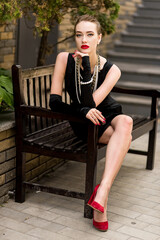 Young female model in black dress in Breakfast at Tiffany's style