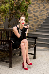 Young female model in black dress in Breakfast at Tiffany's style